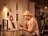 A woman is working on her laptop at a desk in a home office setting. Produktbild-Vorschau