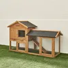 A wooden rabbit hutch with a black roof sits on artificial grass in front of a white brick wall. Produktbild-Vorschau