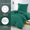 A bed with green bedding, with text and icons on the left side indicating package contents. Produktbild-Vorschau