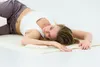 A woman is lying on a yoga mat. Produktbild-Vorschau
