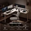 An L-shaped standing desk setup in a home office environment at night. Produktbild-Vorschau