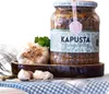 A jar of pickled cabbage with mushrooms, a head of garlic, and parsley on a checkered cloth. Produktbild-Vorschau