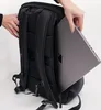 A person is placing a laptop into a black backpack. Produktbild-Vorschau