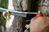A hand is using a STUBAI Wagner-Reifmesser to shave bark off a tree trunk. Podgląd zdjęcia produktu