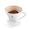 A white ceramic pour-over coffee filter with coffee grounds inside and a paper filter. Produktbild-Vorschau