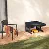 An outdoor patio scene with a chair, a robotic mower garage, and a yellow object underneath the garage. Produktbild-Vorschau