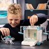 A young boy playing with a toy dinosaur and a toy battle cave. Voir les images du produit