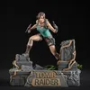 Lara Croft statue from Tomb Raider, posed dynamically on a stone ruin base with the game's title. Anteprima dell’immagine prodotto