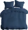 A navy blue duvet cover and two pillowcases with ruffled edges are laid out on a white background. Anteprima dell’immagine prodotto