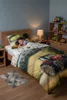 A child sleeping in a bed with tractor-themed bedding in a bedroom. Produktbild-Vorschau