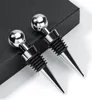 Two silver and black wine stoppers are placed on a black surface. Produktbild-Vorschau