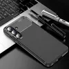 A smartphone case with a carbon fiber look is placed on a laptop keyboard, next to two pens. Produktbild-Vorschau