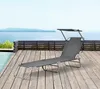 A grey chaise lounge with a sunshade sits on a wooden deck next to a swimming pool, with a body of water and distant hills in the background. Produktbild-Vorschau