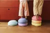 Two children standing on colorful stepping stones in a kitchen. Anteprima dell’immagine prodotto