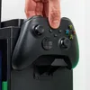 A hand is holding an Xbox controller over a black gaming locker. Podgląd zdjęcia produktu