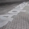 A close-up view of a textured fabric with white lettering on it. Podgląd zdjęcia produktu