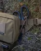 A close-up of a green hip pack with black scissors attached to the side, resting on the ground. Produktbild-Vorschau
