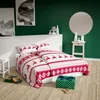 A bedroom scene with Christmas-themed bedding and gifts. Podgląd zdjęcia produktu