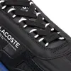 Close-up of the top part of a black sneaker, showing the laces and the Lacoste logo. Produktbild-Vorschau