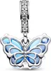 A close-up studio shot of a silver charm shaped like a butterfly with blue enamel wings. Podgląd zdjęcia produktu