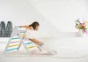 A young girl is sliding down a wooden climbing structure indoors. Voir les images du produit