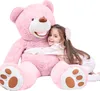 A young girl hugging a large pink teddy bear. Podgląd zdjęcia produktu