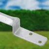 A close-up of a metal bracket with two holes, set against a blurred background of green bushes and a blue sky. Produktbild-Vorschau