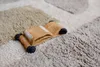 A close-up of a folded toy car on a textured rug. Voir les images du produit