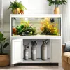 A well-lit aquarium setup with plants, fish, and CO2 tanks stored in the cabinet below. Anteprima dell’immagine prodotto