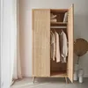 A wooden wardrobe with rattan detailing, open to reveal clothes hanging inside. Produktbild-Vorschau