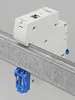 A white circuit breaker is mounted on a silver metal rail with a blue clip. Produktbild-Vorschau