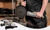 A person is using an angle grinder in a workshop setting. Another angle grinder is shown in the foreground. Náhled obrázku produktu