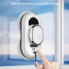 A robotic window cleaner is shown attached to a window, with a hand plugging in its charging cable. Náhľad obrázku produktu