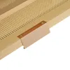 A close-up shot of a wooden furniture piece with a woven rattan insert and a copper-colored handle attached with screws. Produktbild-Vorschau