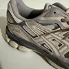 Close-up side view of a grey Asics sneaker. Produktbild-Vorschau