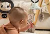A baby is playing with a gymini toy. Produktbild-Vorschau