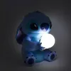 A blue Stitch figurine holding a glowing white orb. Produktbild-Vorschau