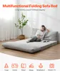 A woman is relaxing on a multifunctional folding sofa bed, which is laid out flat. Voir les images du produit
