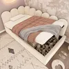 A child's bed with storage, featuring a scalloped headboard and a pink blanket. Produktbild-Vorschau