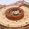 Close-up view of a wooden 3D puzzle carousel mechanism with gears and wires. Produktbild-Vorschau