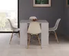 A dining set with a white table and chairs in a room with a large window. Produktbild-Vorschau
