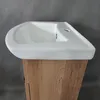 A close-up view of a white sink on a wooden cabinet. Podgląd zdjęcia produktu