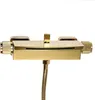 A close-up studio shot of a gold-colored shower faucet with a flexible hose attached. Podgląd zdjęcia produktu