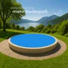 A round swimming pool with a blue cover sits on a grassy lawn, with a lake and mountains in the background. Náhled obrázku produktu