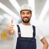 A construction worker wearing a hard hat and overalls gives a thumbs up. Produktbild-Vorschau