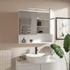A modern bathroom vanity with a sink, faucet, and a mirrored cabinet with LED lighting. Produktbild-Vorschau