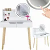 A white dressing table with wooden legs and a round LED mirror, decorated with makeup and a small vase of flowers. Produktbild-Vorschau