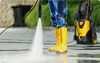 A person wearing yellow boots and blue work pants is pressure washing a paved surface with a yellow and black pressure washer in the background. Náhľad obrázku produktu