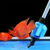 Several orange fish are swimming in an aquarium near a blue and white automatic gravel cleaner. Náhled obrázku produktu