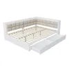 A white daybed with a beige upholstered headboard and two open drawers underneath, shown from a diagonal angle against a white background. Náhled obrázku produktu